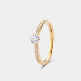 Ring AURA Rund in Gelbgold, Schrägansicht – kleine Diamanten auf beiden Seiten der Ringschiene führen zum runden Brillanten