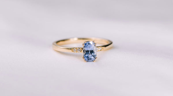 Maßgefertigter Verlobungsring aus 585er Gelbgold mit blauem Saphir im Antik-Schliff und kleinen Diamanten – handgefertigt von JUVELAN.