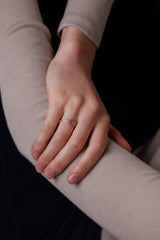 Ring AURA Oval von JUVELAN in Gelbgold an der Hand getragen – ovaler Diamant mit feinem Diamantbesatz auf der Ringschiene, Hand entspannt auf dem Arm