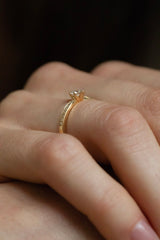 Ring AURA Rund in Gelbgold am Finger, seitliche Ansicht – Diamantbesatz auf der Ringschiene und niedrige Sechs-Krappen-Fassung mit rundem Brillanten