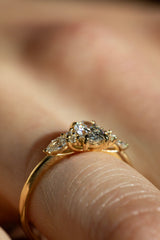 Ring DAWN in Gelbgold am Finger, Nahaufnahme – ovaler Diamant in Krappenfassung, flankiert von Tropfen und kleinen Brillanten