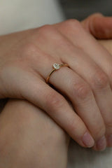Ring NOVA Oval von JUVELAN in Gelbgold an der Hand getragen, Nahaufnahme – ovaler Diamant-Solitär in niedriger Vier-Krappen-Fassung auf zarter Ringschiene