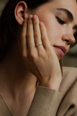 Ring NOVA Rund von JUVELAN in Gelbgold an der Hand getragen – Solitär-Verlobungsring mit rundem Diamanten, Hand an die Wange gelegt