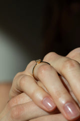 Ring SOL in Gelbgold am Finger, seitliche Nahaufnahme – niedrige Sechs-Krappen-Fassung mit rundem Brillanten auf schmaler Ringschiene