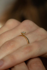 Ring VEGA in Gelbgold am Finger, seitliche Ansicht – hoch gefasster Tropfendiamant auf schmaler Ringschiene